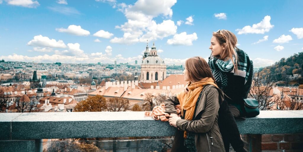 Tourists enjoying panoramic view of Prague city and St. Nicholas Church from viewpoint